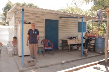 Eduardo standing on the front porch of his home in El Salvador